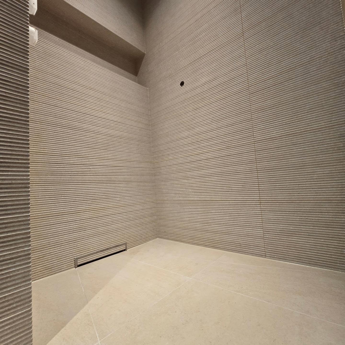 Houseboat shower with textured tiles and a recessed drain
